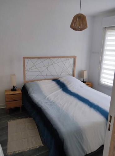 - une chambre avec un grand lit et une couverture bleue dans l'établissement Joli T2 dans résidence calme, à Caen