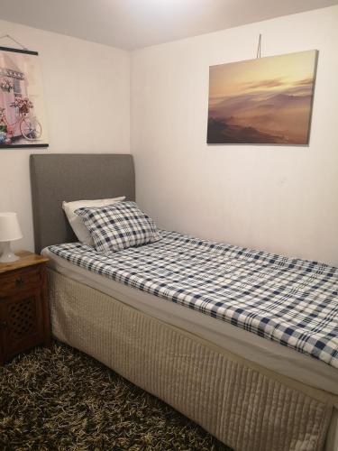 uma cama num quarto com uma fotografia na parede em Minilägenhet em Gotemburgo