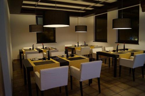 a dining room with yellow tables and white chairs at Hotel am Kirchplatz in Sachsenheim