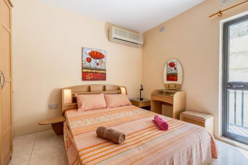 - une chambre avec un grand lit et une fenêtre dans l'établissement Nice seaview apt at St Paul's Bay, à San Pawl il-Baħar