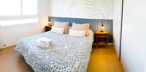 1 dormitorio con 1 cama con colcha azul y blanca en Sierras de Tandil Departamentos en Tandil