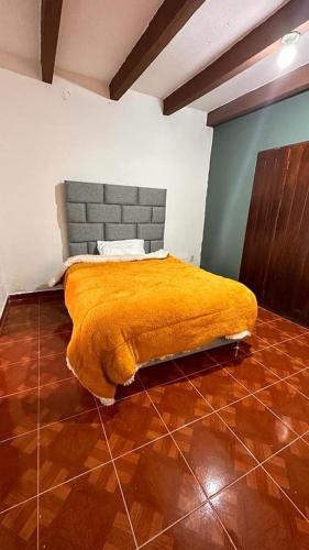 um quarto com uma cama com um cobertor amarelo em Hotel Don Quijote em Mineral de Pozos