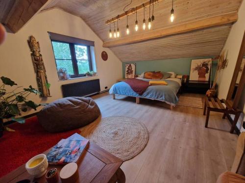 um quarto com uma cama e uma sala de estar em Maison familiale avec jacuzzi et jardin au calme em Sprimont