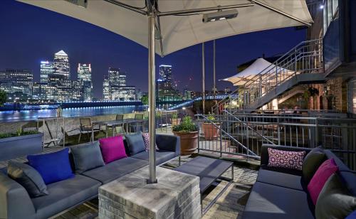 a living room filled with furniture next to a river at DoubleTree by Hilton London – Docklands Riverside in London