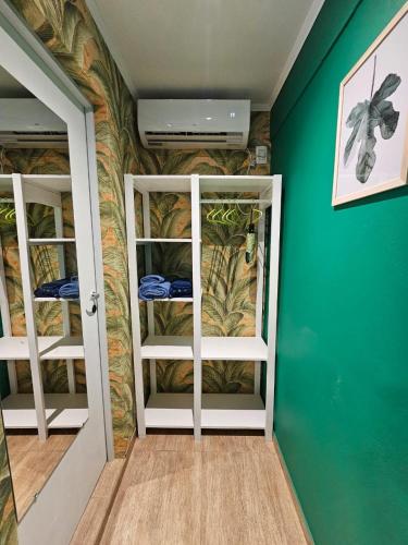 a room with two bunk beds in a room with green walls at Casa 24 Puerto Iguazu in Puerto Iguazú
