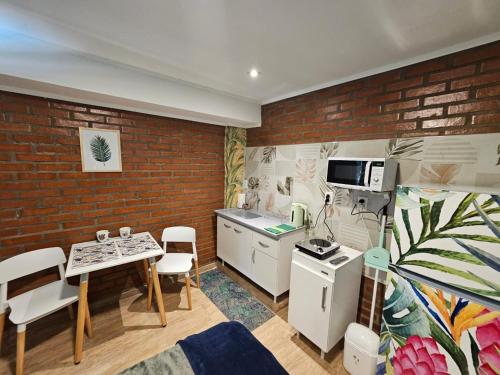 een keuken met een bakstenen muur en een tafel met stoelen bij Casa 24 Puerto Iguazu in Puerto Iguazú