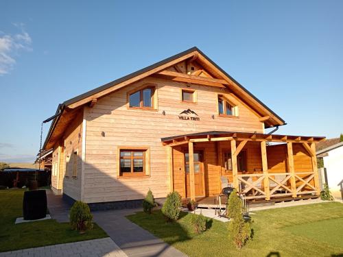 une grande maison en bois avec un gambrel dans l'établissement Villa Triti, à Stará Lesná