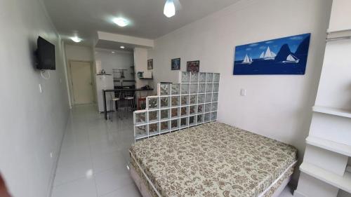 um quarto com uma cama no meio de um quarto em Flats Boulevard Center Pitangueiras no Guarujá