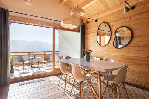 une salle à manger avec une table et des chaises sur un balcon dans l'établissement Alpe d'Huez Houses - Chez Gaston - Comme un chalet 4 chambres pour 10p, à L'Alpe-d'Huez