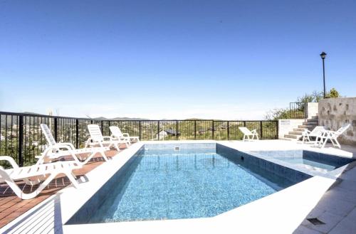 einen Pool mit Liegestühlen und einem Pool in der Unterkunft Complejo Lamarca in Villa Carlos Paz