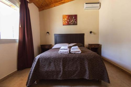 ein Schlafzimmer mit einem Bett mit zwei Handtüchern darauf in der Unterkunft Complejo Lamarca in Villa Carlos Paz