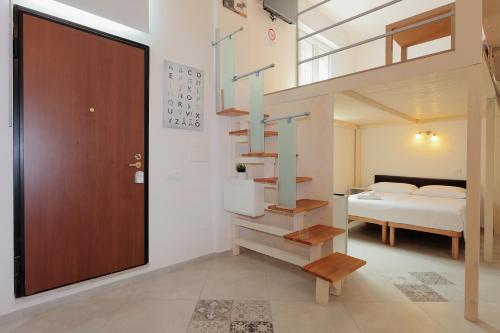 ボローニャにあるLa Ca' Fiera Affittaly Apartmentsの階段付きの部屋、ベッド付きのベッドルーム1室が備わります。