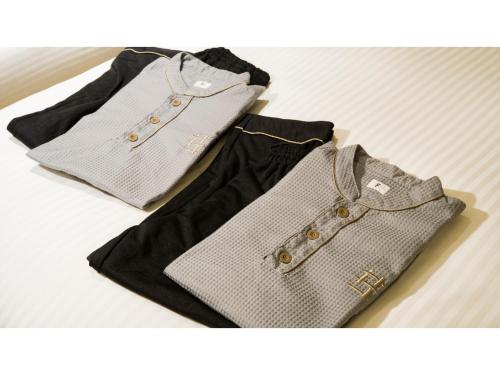 two shirts and a purse sitting on a table at GRIDS Premium Hotel Otaru - Vacation STAY 68534v in Otaru