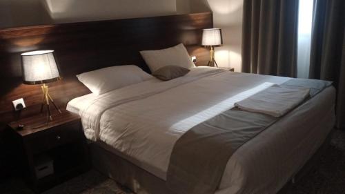 uma cama grande num quarto de hotel com duas lâmpadas em فندق الإحسان em Meca