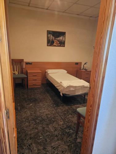 1 dormitorio pequeño con 1 cama y 1 silla en Hotel restaurante Palacio Fes en Murcia