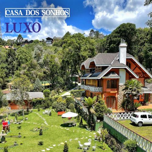 a house on a grassy field in front of a house at Pousada Casa dos Sonhos in Campos do Jordão