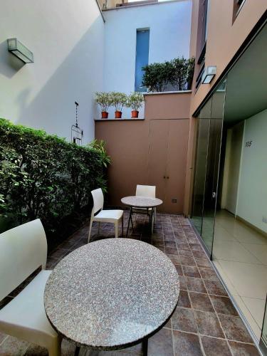 a patio with two tables and chairs in a building at 3B Barranco by Katari Hoteles in Lima