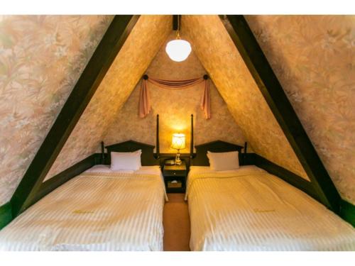 two beds in a room with a roof at Restaurant & Hotel Traumerei - Vacation STAY 47770v in Hakuba