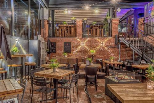 a restaurant with tables and chairs and a brick wall at NOVA L-Elite in Szczecin