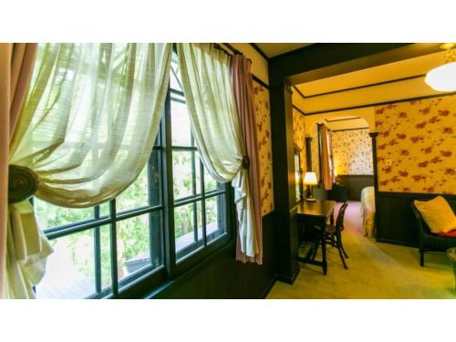 a bedroom with a window and a bed and a desk at Restaurant & Hotel Traumerei - Vacation STAY 47810v in Hakuba