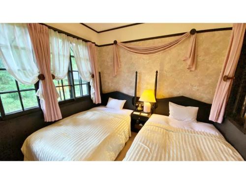 - 2 lits dans une chambre avec 2 fenêtres dans l'établissement Restaurant & Hotel Traumerei - Vacation STAY 16060v, à Hakuba