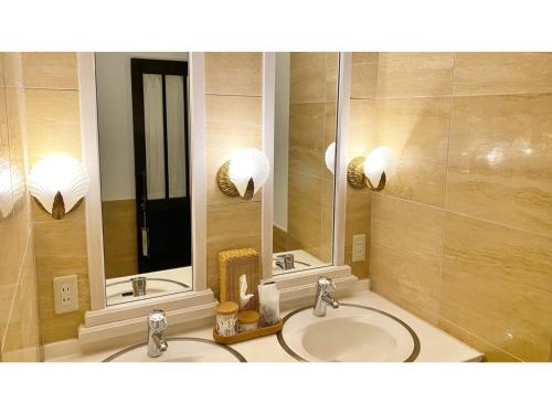 La salle de bains est pourvue de 2 lavabos et de 2 miroirs. dans l'établissement Restaurant & Hotel Traumerei - Vacation STAY 16060v, à Hakuba