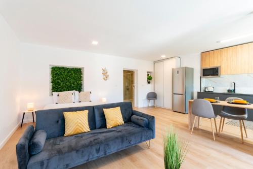 a living room with a blue couch and a kitchen at Loriga View Apartments in Loriga