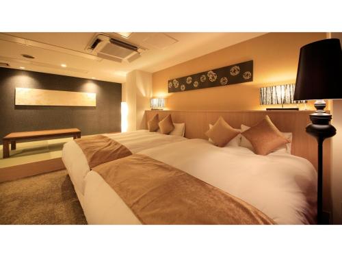 ein Schlafzimmer mit einem großen Bett und einem Schreibtisch in der Unterkunft Centurion Hotel Villa Suite Fukui Ekimae - Vacation STAY 34650v in Fukui