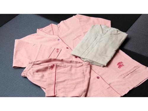 ein Haufen rosafarbener Kleidung auf dem Boden in der Unterkunft Centurion Hotel Villa Suite Fukui Ekimae - Vacation STAY 34650v in Fukui
