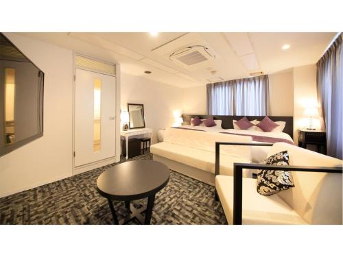 福井市にあるCenturion Hotel Villa Suite Fukui Ekimae - Vacation STAY 34640vのベッド2台とソファが備わるホテルルームです。