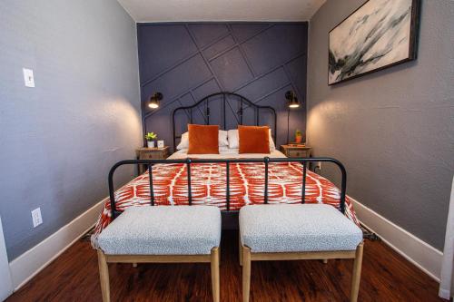 um quarto com uma cama com almofadas laranja e 2 cadeiras em Historic Apt Mins to Beach, Convention Center, Downtown w Free Parking em Long Beach