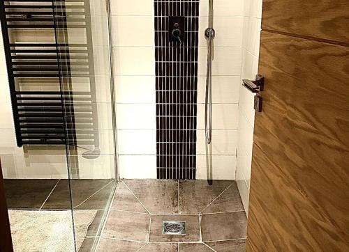 une douche avec une porte vitrée dans une salle de bain dans l'établissement Modern apartment , Golfe de Saint Tropez, à Cogolin