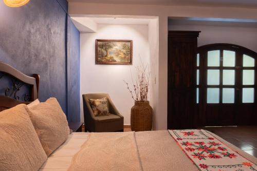 a bedroom with a bed and a chair and a window at Hotel Paraíso Encantado in Xilitla