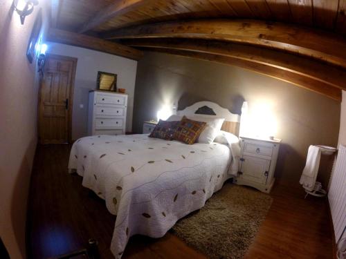 um quarto com uma cama grande e um tecto em madeira em Casa La Charca 