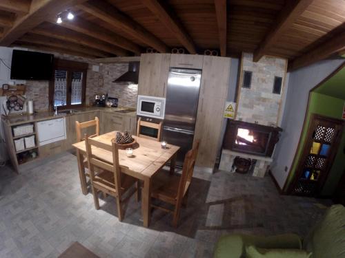 uma cozinha com uma mesa de madeira e um frigorífico em Casa La Charca 