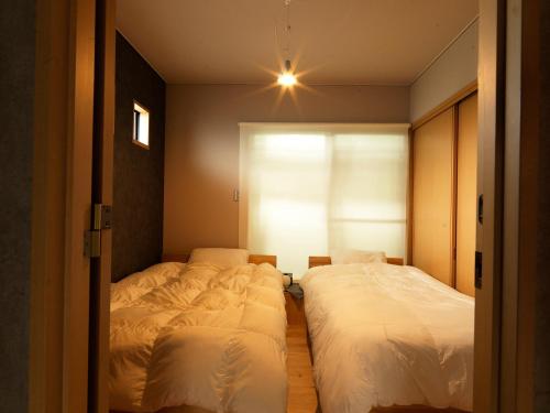 富士吉田的住宿－urban"s camp fuji - Vacation STAY 54448v，一间卧室设有两张床和窗户。