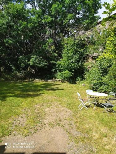 a picnic table and two chairs in a yard at Volca'séjour in Orcines