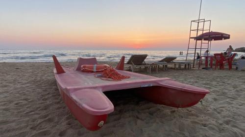 a pink boat sitting on the beach at sunset at Mediterranean Sunset Villa in Punta Braccetto