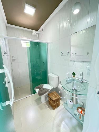 a bathroom with a glass shower and a toilet and a sink at Chalés Alto dos Milagres in São Miguel dos Milagres