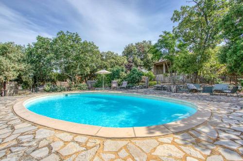 - une piscine dans une cour avec une terrasse en pierre dans l'établissement Maison La Hulotte, à Lussan