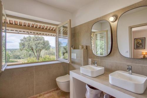 une salle de bain avec deux lavabos et un miroir dans l'établissement Maison La Hulotte, à Lussan