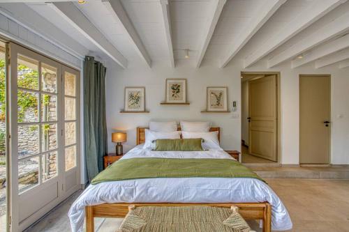 - une chambre avec un grand lit et des fenêtres dans l'établissement Maison La Hulotte, à Lussan