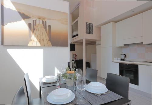a dining room with a table with plates and glasses at La Ca' Fiera Affittaly Apartments in Bologna