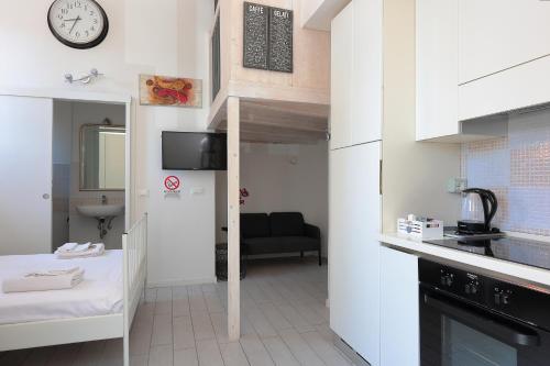 ボローニャにあるLa Ca' Fiera Affittaly Apartmentsのベッド1台、壁掛け時計が備わる小さな客室です。