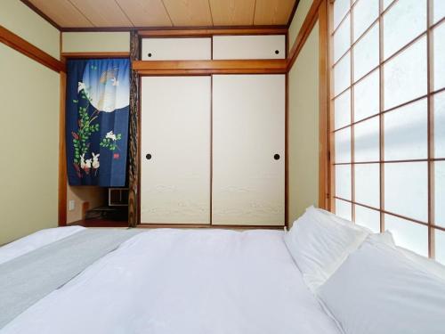 - une chambre avec un lit et une grande fenêtre dans l'établissement Senmagawa - Kuhoji - Vacation STAY 15376, à Yaochō