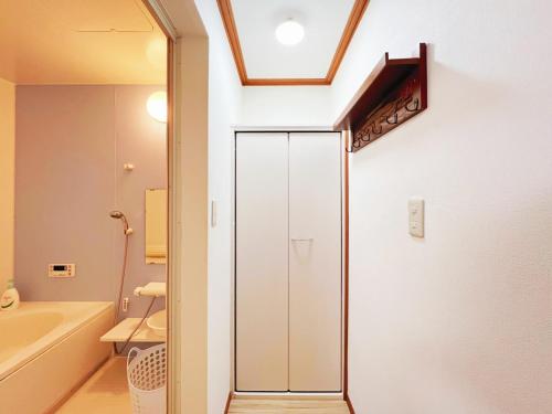 La salle de bains est pourvue d'une porte de douche en verre à côté d'une baignoire. dans l'établissement Senmagawa - Kuhoji - Vacation STAY 15376, à Yaochō