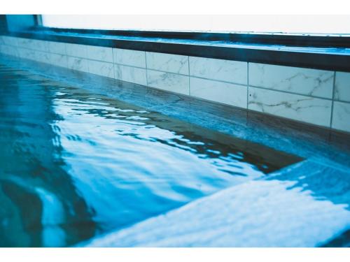a swimming pool with blue water and white tiles at Hotel Grand View Takasaki - Vacation STAY 55450v in Takasaki