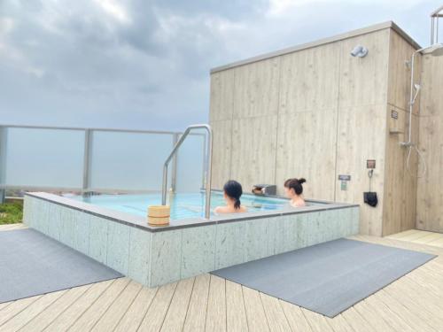 two women in a hot tub on a building at Hotel Grand View Takasaki - Vacation STAY 55450v in Takasaki