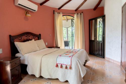 a bedroom with a bed and a large window at Hotel Paraíso Encantado in Xilitla