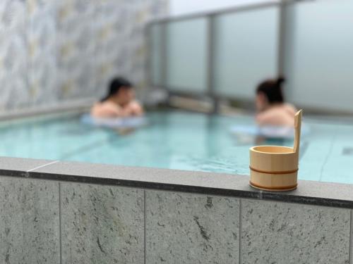 a cup in a swimming pool with two people swimming at Hotel Grand View Takasaki - Vacation STAY 55422v in Takasaki